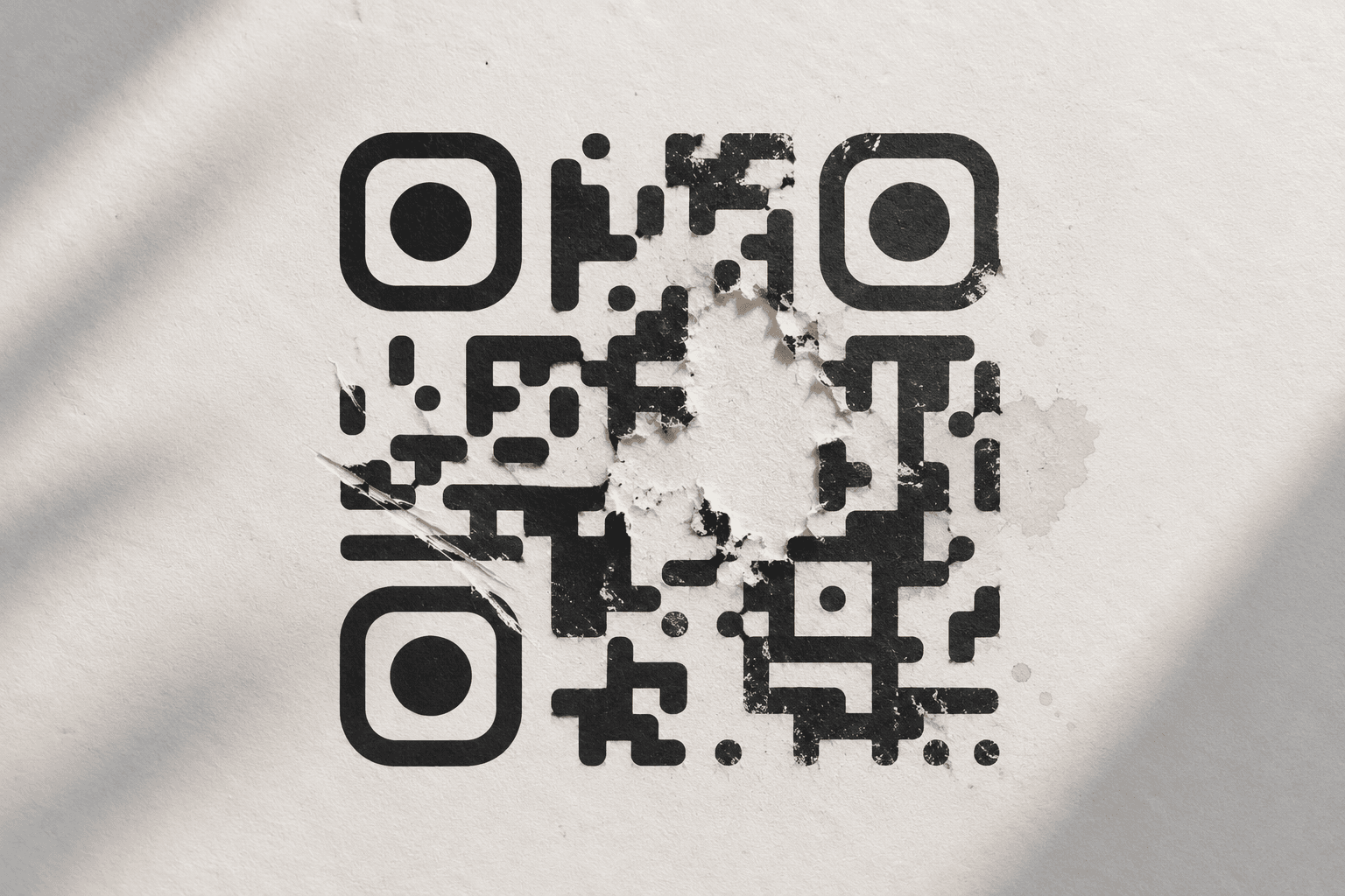 A damaged QR code with part of its pattern missing while remaining readable