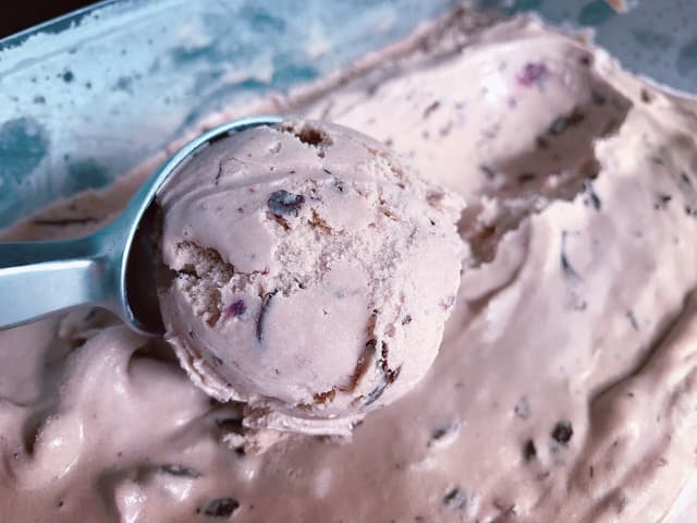 Close up of a scoop being lifted from creamy ice cream